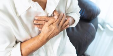 old woman having heart attack and grabbing her chest